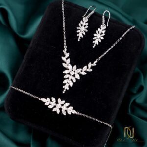 سرویس نقره زنانه طرح شاخه و برگ درخشان ns-s-45، عکس روی جعبه مخمل مشکی، چیدمان آرایشی و مرتب ست نقره با پس زمینه پارچه سبز