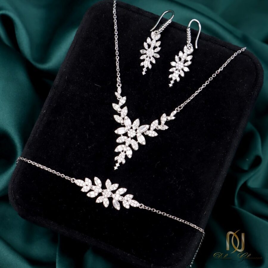 سرویس نقره زنانه طرح شاخه و برگ درخشان ns-s-45، عکس روی جعبه مخمل مشکی، چیدمان آرایشی و مرتب ست نقره با پس زمینه پارچه سبز