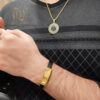 ست گردنبند و دستبند مردانه طرح ورساچ طلایی و مشکی عکس روی دست