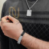 ست دستبند و گردنبند مردانه طرح کارتیر نقره ای عکس روی دست
