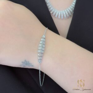سرویس نقره تراش ns-s-2 نمای نزدیک دستبند نقره روی مچ دست، نمایش جزئیات طرح اسلیمی و نگین‌کاری