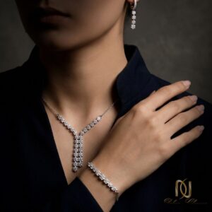 سرویس نقره زنانه طرح فلاور نگیندار مجلسی ns-s-44، مدل wearing ست نقره با گردنبند، گوشواره و دستبند روی پوستر تیره