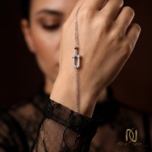 دستبند نقره زنانه پلاک U شکل نگین اتمی br-s-37 روی دست زن با لباس توری، نمای نزدیک پوشیدن