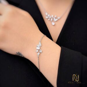 سرویس نقره زنانه پروانه ns-s-29 نمای دستبند نقره بر روی مچ دست با گردنبند در پس‌زمینه