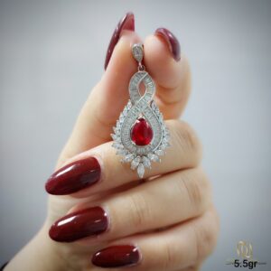 گردنبند نقره زنانه مجلسی طرح اشک ne-new-97، عکس دست نگهدارنده، نمای نزدیک با سنگ قرمز مرکزی و حاشیه الماس باغوتی