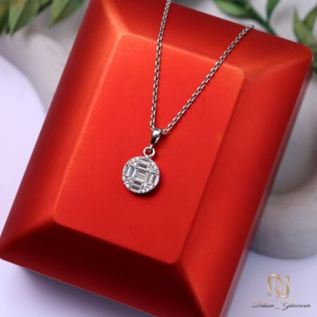 گردنبند نقره زنانه پلاک دایره ای نگین باگت ظریف ne-new-81، عکس روی جعبه نمایش قرمز با برگ‌های سبز