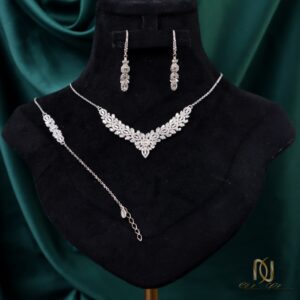 سرویس نقره زنانه طرح هفتی مجلسی ns-s-49 روی مانکن گردن مشکی با پس زمینه ابریشم سبز، نمایش گردنبند و گوشواره