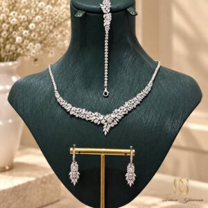 سرویس نقره زنانه مجلسی خوشه برگی ns-s-71 عکس روی مانکن نمایشی سبز، نمایش کامل ست شامل گردنبند و گوشواره و دستبند روی استند طلایی